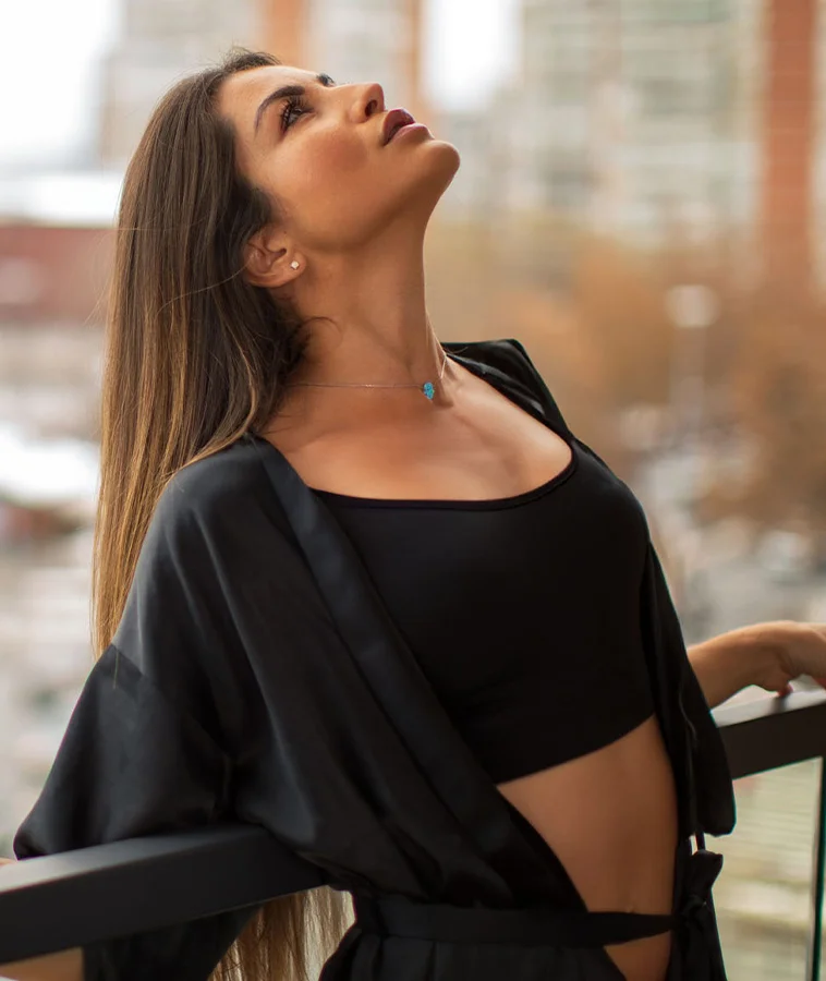 Woman on a balcony looking up with great chin implant | Cohn Plastic Surgery Long Island